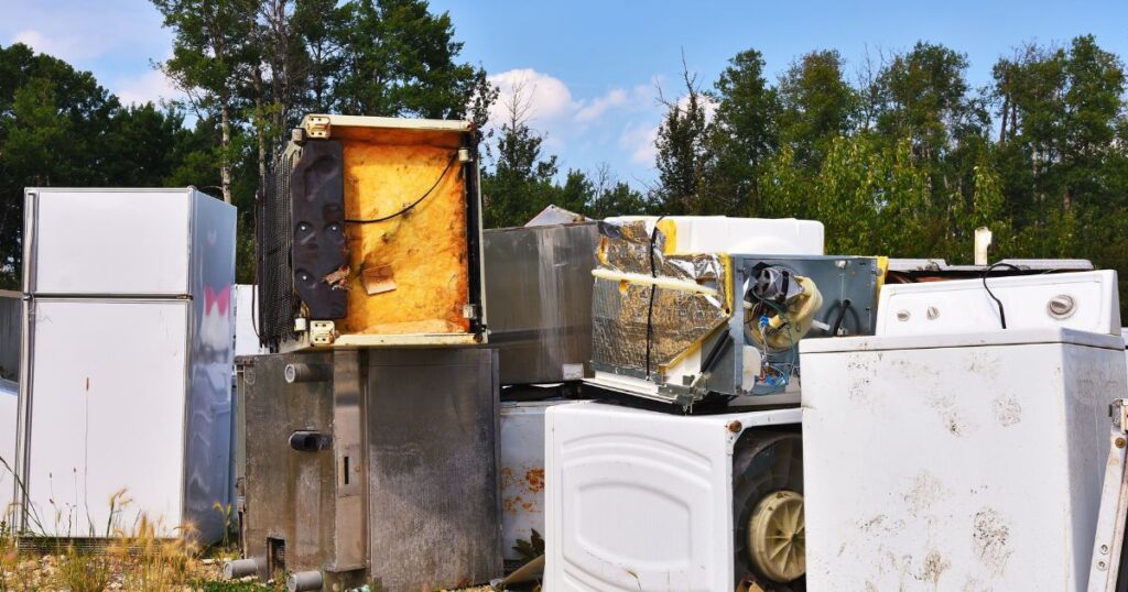 Broken washer and dryer being removed from a home for eco‑friendly disposal.